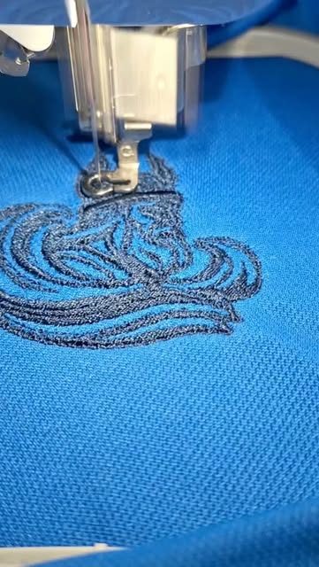 A wave design embroidered onto a blue polo